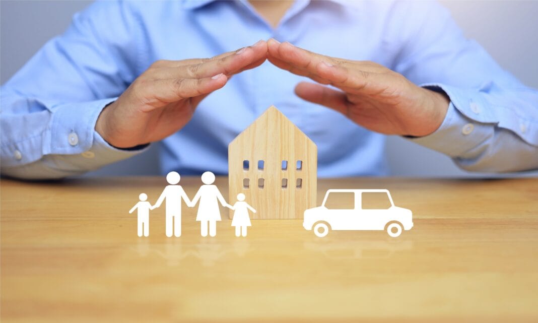life insurance concept with businessman using his hands to protect his family home and car, meaning to protect the health and property of the people in the home and to plan for the future.