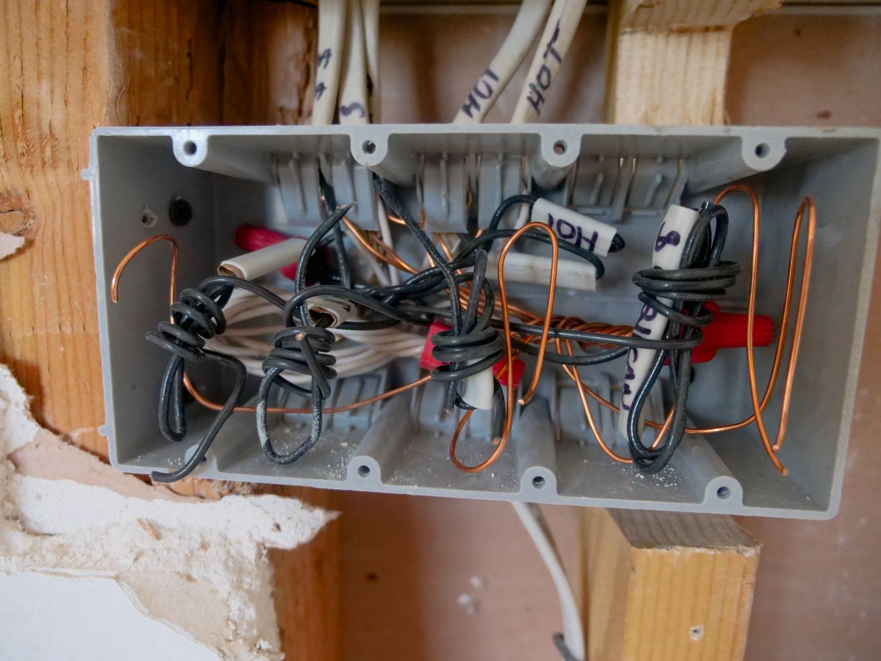 Otwarta rozdzielnica elektryczna z plątaniną przewodów i kabli