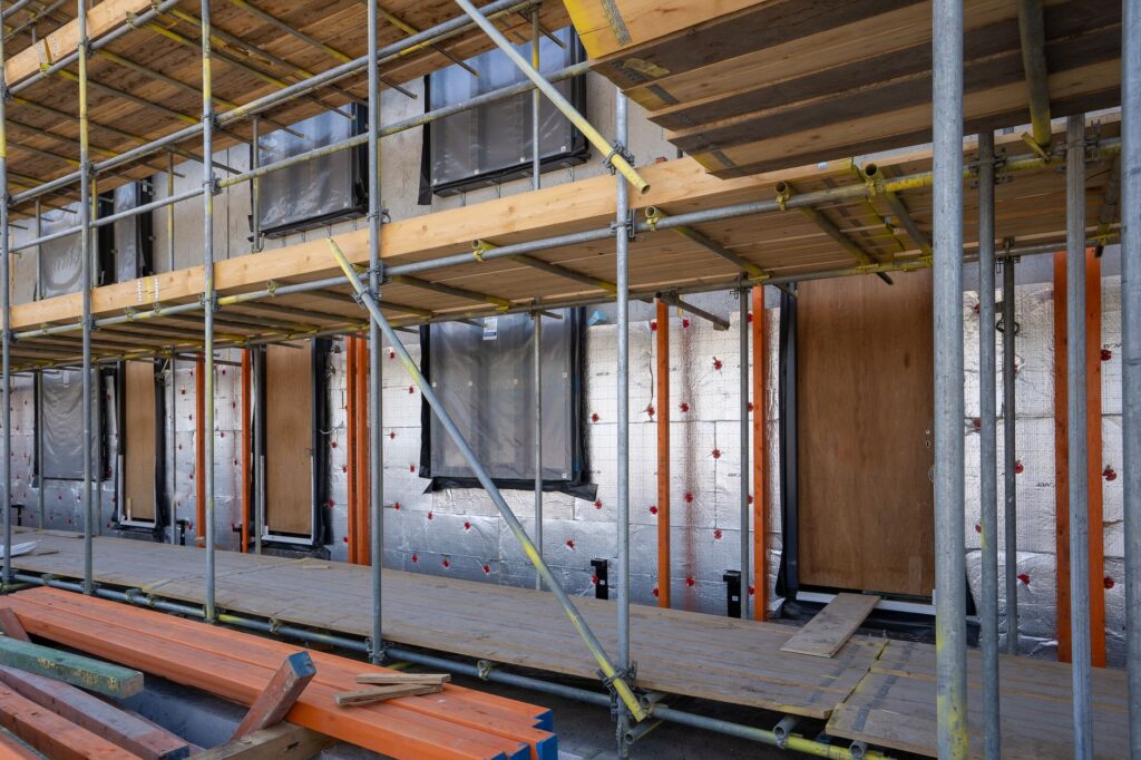 Rusztowanie przy budowanym domu z widoczną izolacją ścian